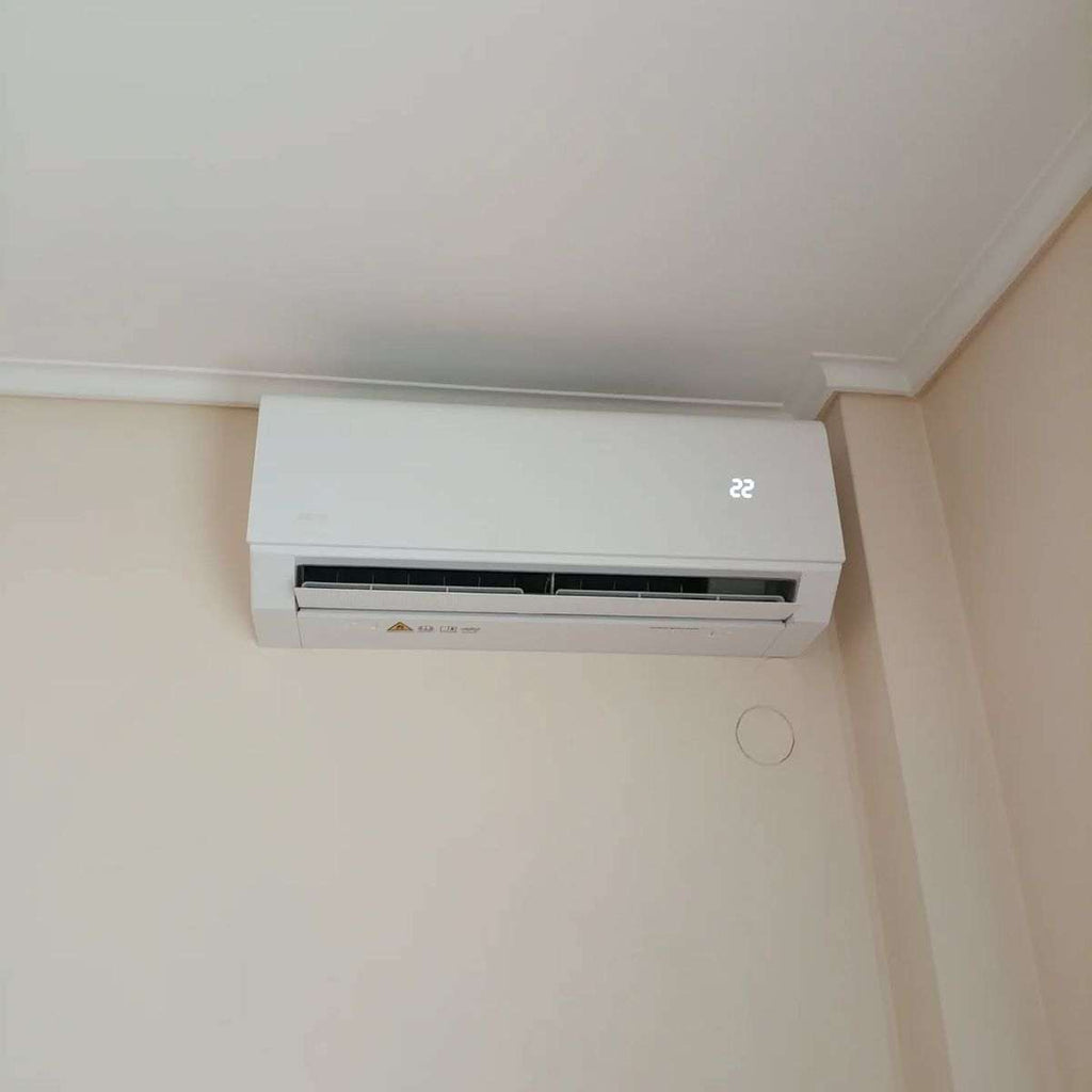 Wall mounted air conditioner heater 2-in-1 cooling and heating unit installed on a white wall in a room