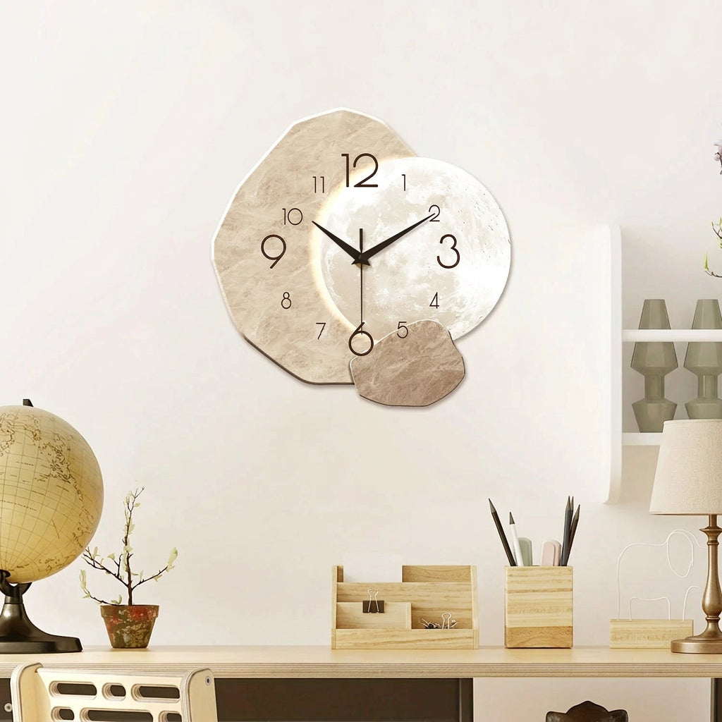 A modern floating wall clock with three irregular stone-like circular faces in beige, white, and taupe tones, displayed on a white wall above a desk with a globe, small plant, and stationery. A '2D' badge appears in the top-left corner.