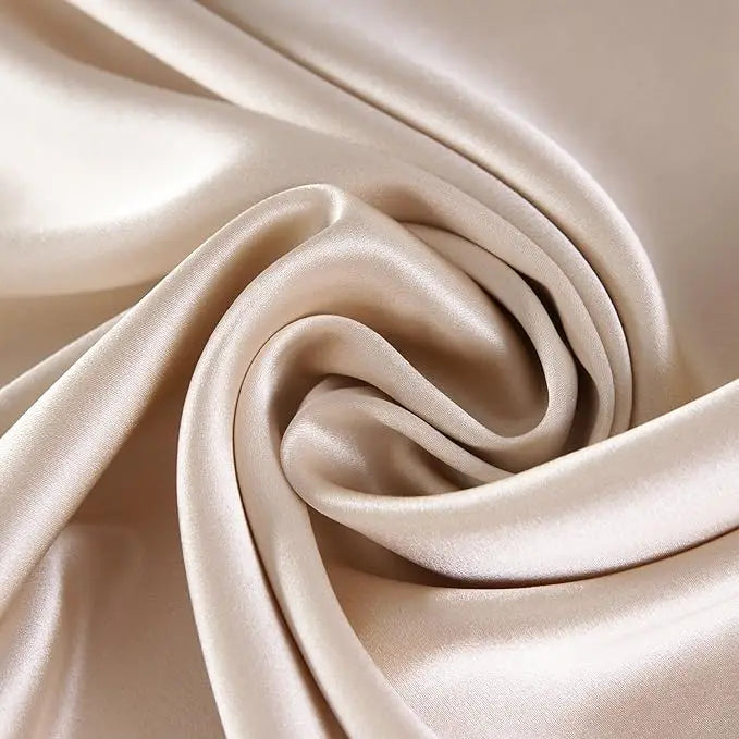 Close-up of beige satin fabric with folds